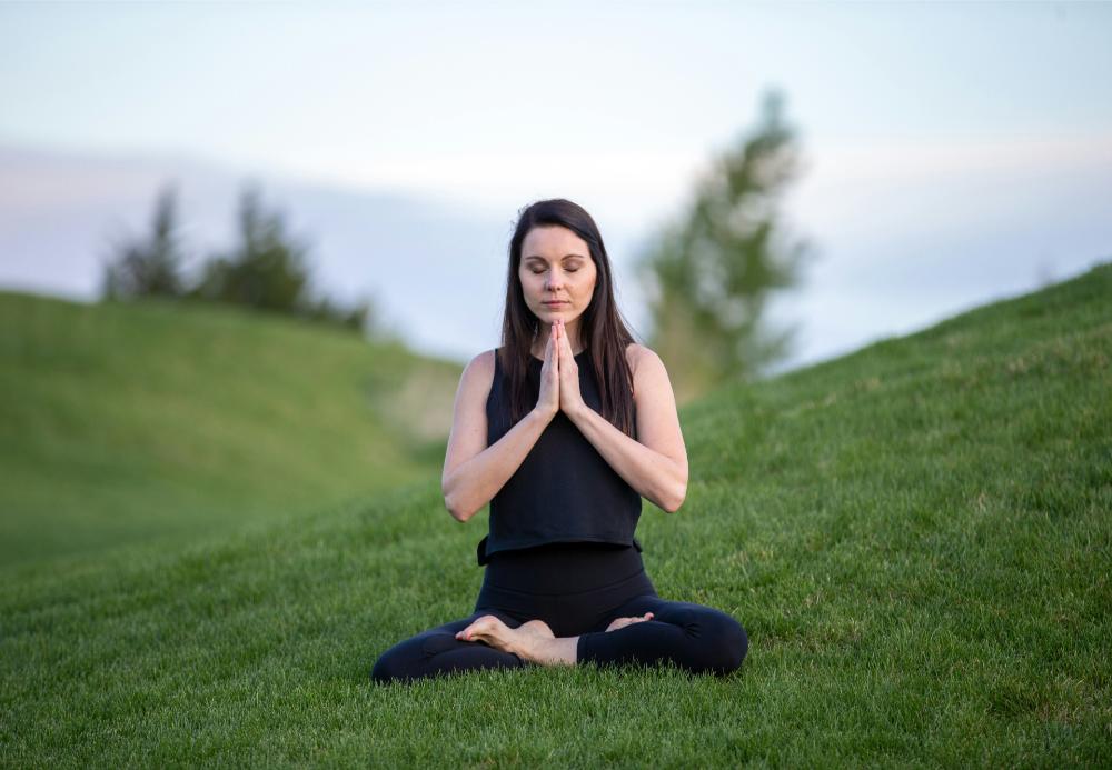 Woman meditating outside, peaceful setting